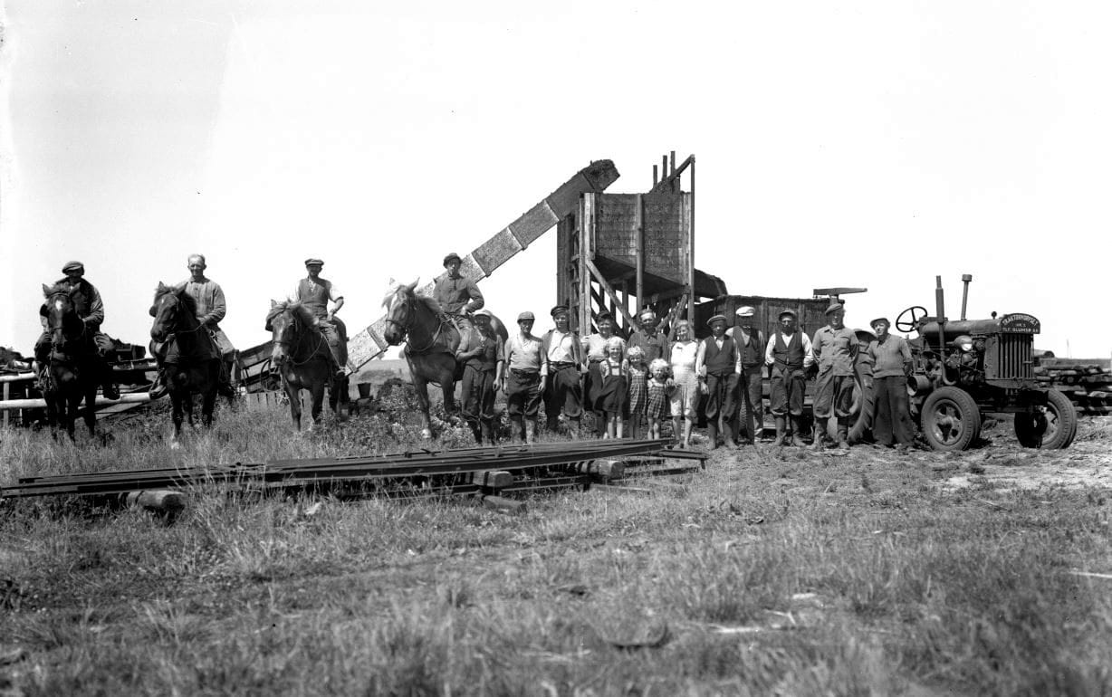 62.8.1 62.8 viser gårdejer Toftegård Jensen på Kildegården. Kirkebakkevej 3, Munke-Bjergby. Toftegård ses yderst til højre med sit tørvehold. Tørvemosen ligger nedenfor gården ved Munke-Bjergby sø. Traktoren en Fordson er lejet ved Traktorkorpset i Glumsø. Det der i dag hedder C.C Brun Enterprise A/S i Herlufmagle.