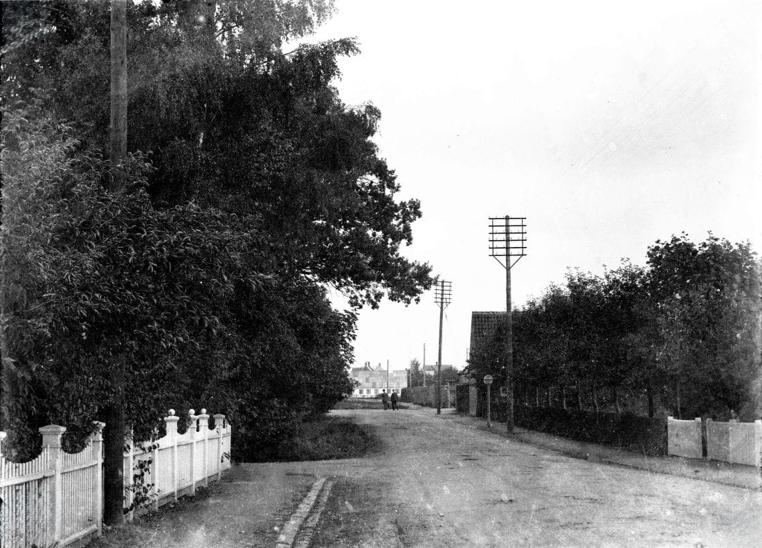 423.1 Hovedgaden med fabrikant Møllers villa. Derefter indkørsel og rækværk til savværket. Den hvide bygning for enden kunne være den gamle smedje